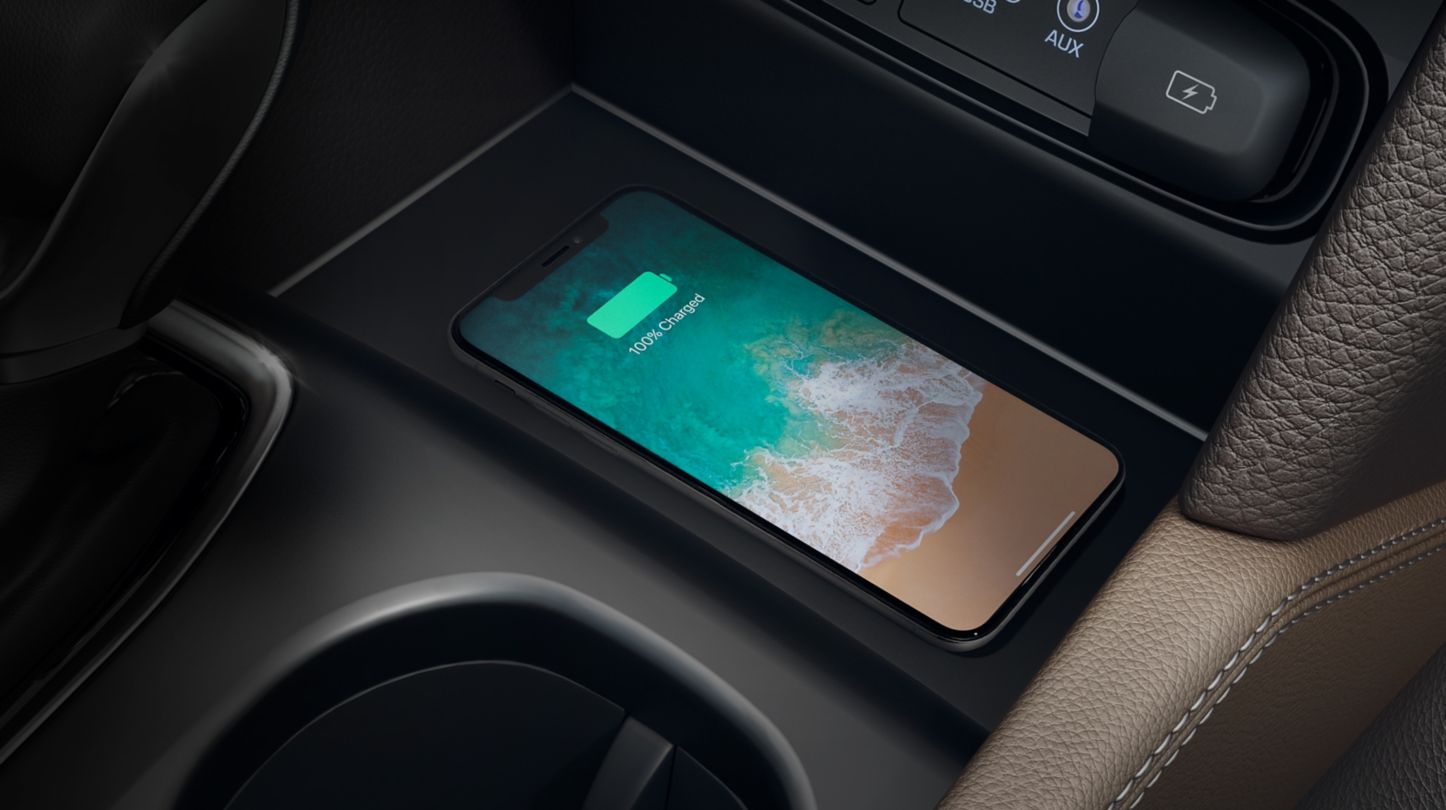 A Qi-enabled smartphone in a wireless charging tray of a Hyundai centre console.