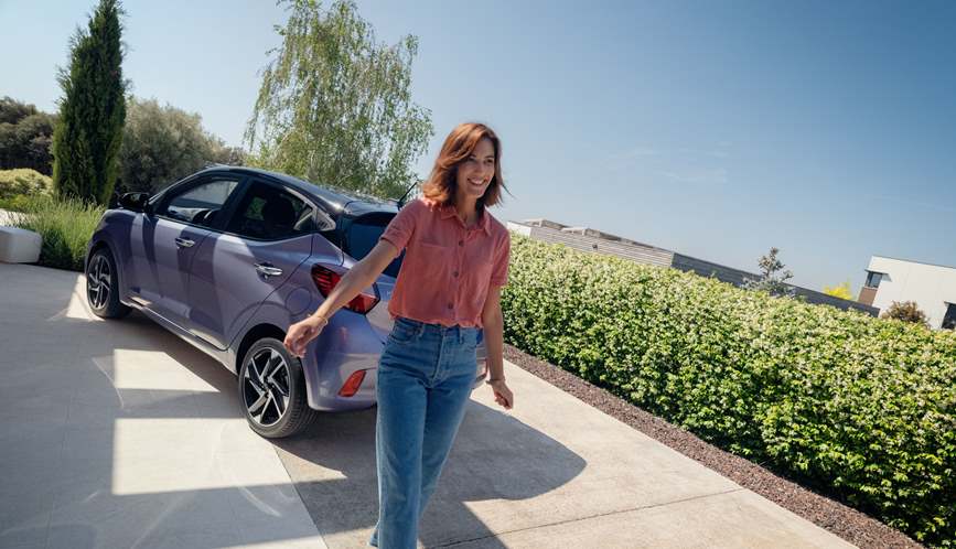 Woman in red sweater leaning on the doors of the new Hyundai i30.
